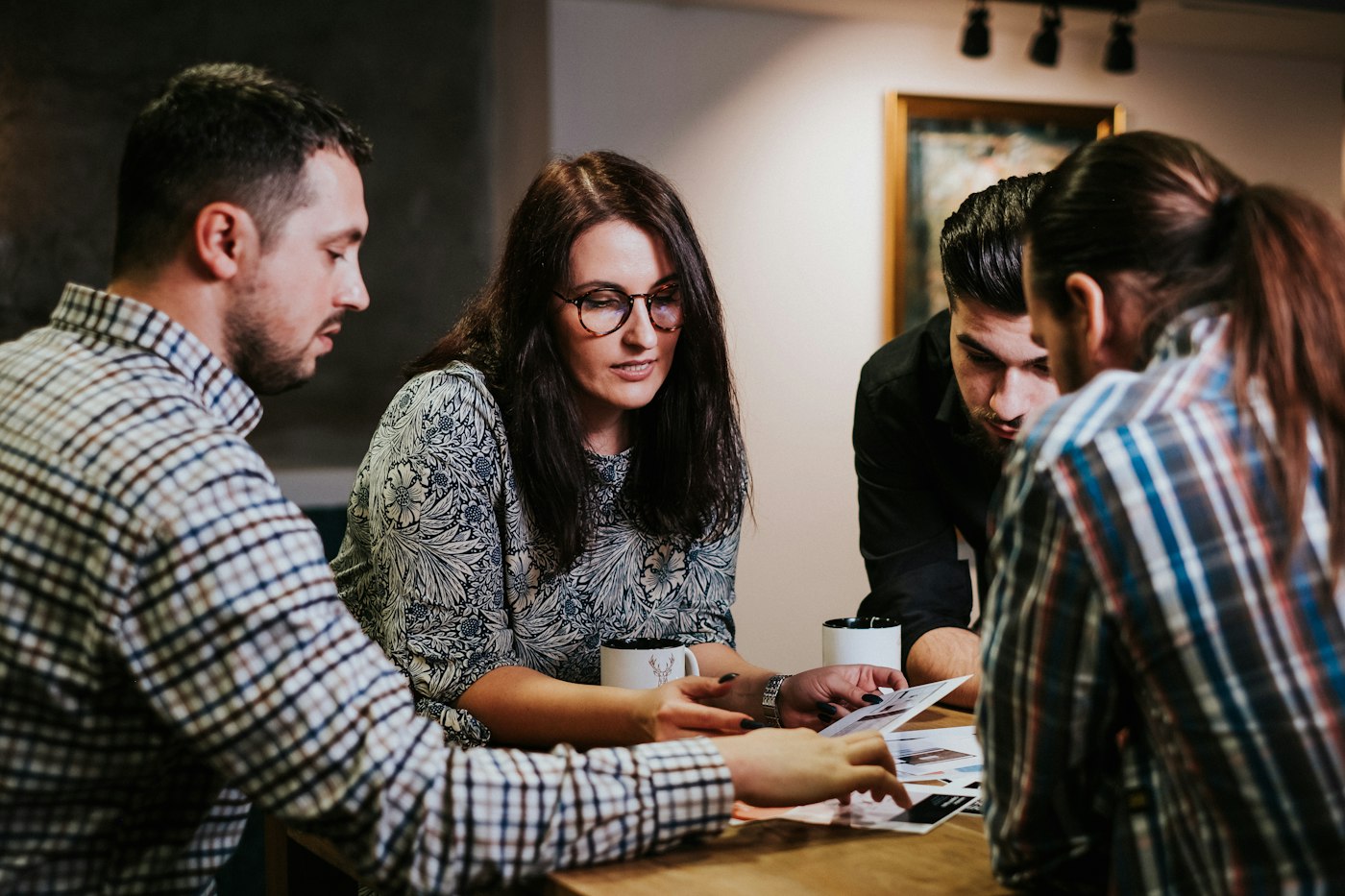 Advisors and students reviewing printed documents together at a workshop table
