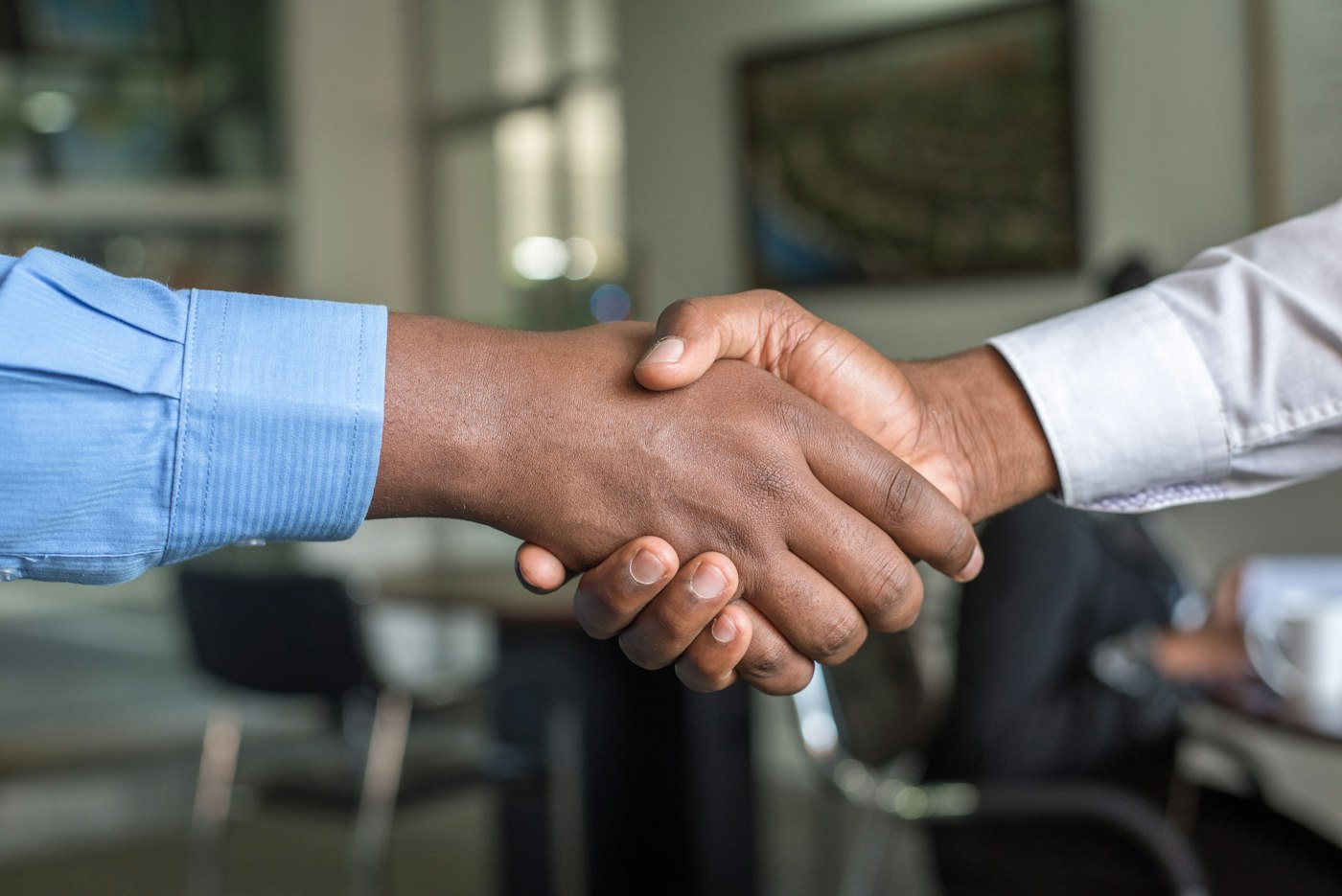 Two people shaking hands at the end of an admission interview