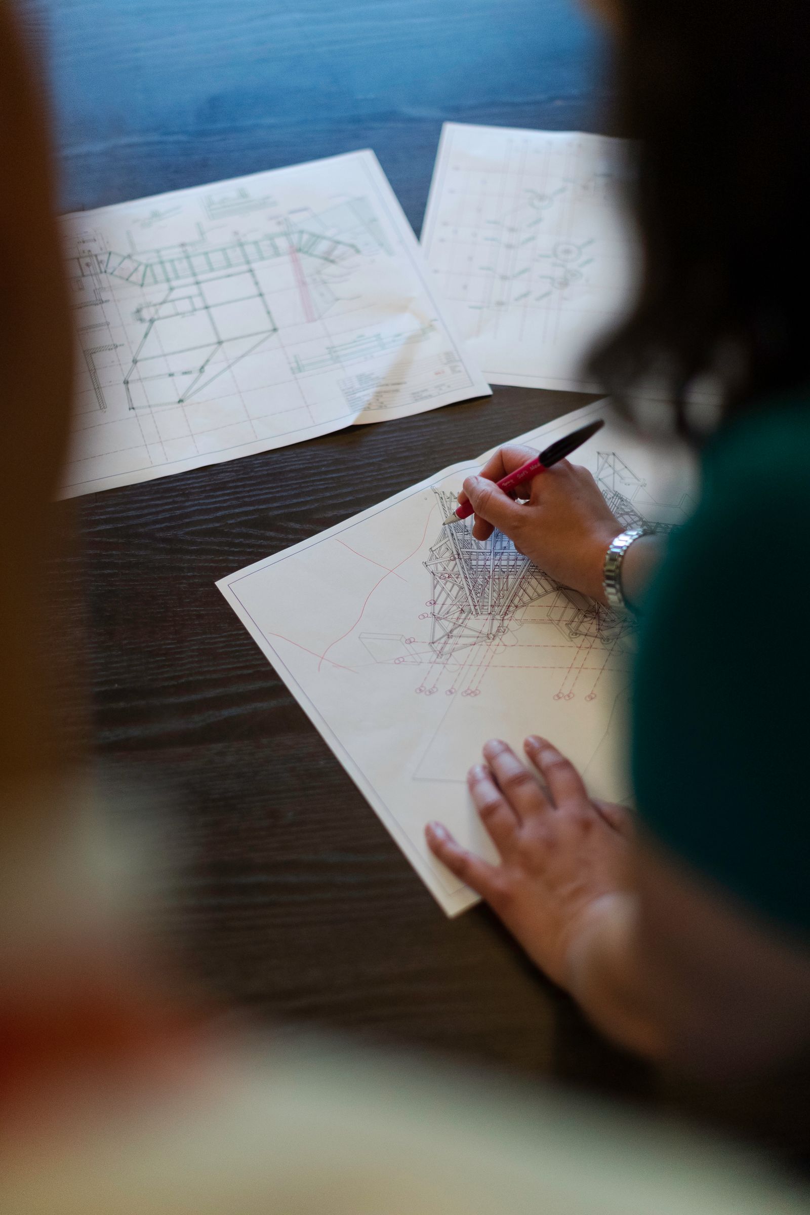 Student sketching an engineering design on paper at a desk